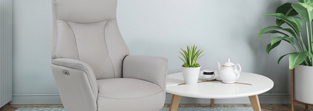 Closeup picture of a grey swivel recliner chair next to a table.